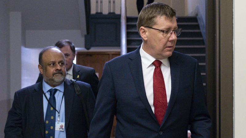 Premier of Saskatchewan Scott Moe and Saqib Shahab, chief medical health officer, arrive to a COVID-19 news update at the Legislative Building in Regina on Wednesday March 18, 2020. THE CANADIAN PRESS/Michael Bell