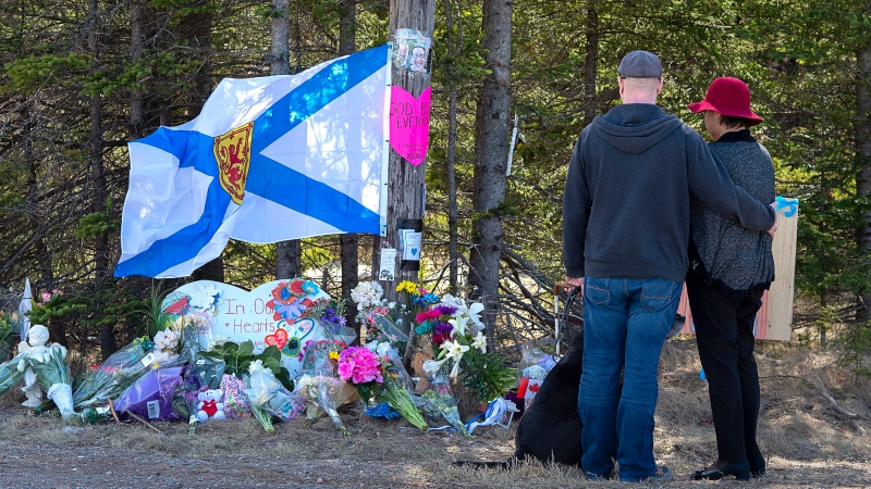 A couple pays their respects at a roadblock in Portapique, N.S. on Wednesday, April 22, 2020. RCMP say at least 22 people are dead after a man, who at one point wore a police uniform and drove a mock-up cruiser, went on a murder rampage in Portapique and several other Nova Scotia communities. THE CANADIAN PRESS/Andrew Vaughan