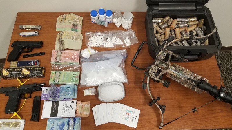 Police display cash, drugs, weapons and ammunition allegedly seized during a search of a Bracebridge home on Wednesday, April 29, 2020. (OPP)
