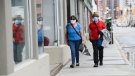 A couple wear masks while out for a walk in downtown Ottawa during the COVID-19 pandemic on Friday, May 1, 2020. THE CANADIAN PRESS/Sean Kilpatrick