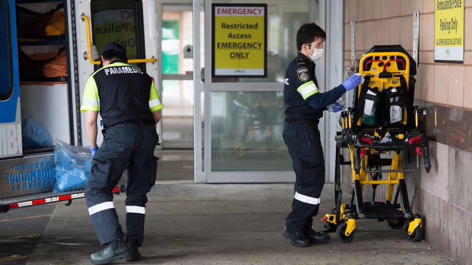 Paramedics disinfect medical equipment after transporting a patient to the emergency department at a hospital during the COVID-19 pandemic in Toronto on Thursday, April 30, 2020. (Nathan Denette/The Canadian Press)