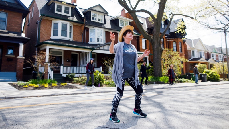 Donna McDougall leads a line dancing workout in her Roncesvalles neighbourhood in Toronto, Wednesday, May 6, 2020. THE CANADIAN PRESS/Cole Burston