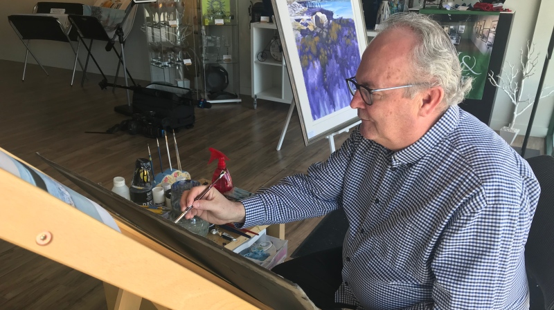 Watercolour artist Ed Roach paints in the window of Sissy and Roche in Kingsville, Ont., on Thursday, May 7, 2020. (Angelo Aversa/CTV Windsor)
