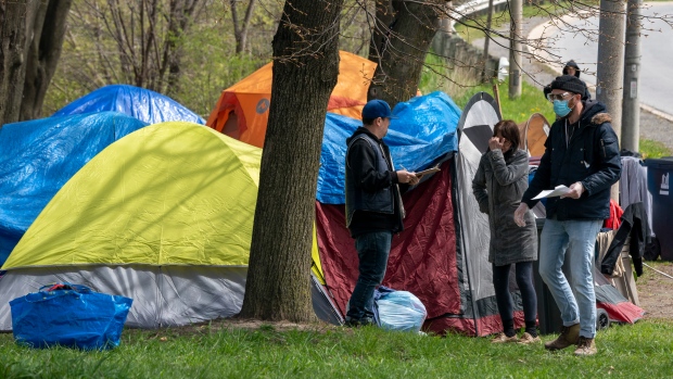 Outreach workers from The Salvation Army visit with residents of a roadside tent encampment n Toronto on Tuesday May 5, 2020. THE CANADIAN PRESS/Frank Gunn