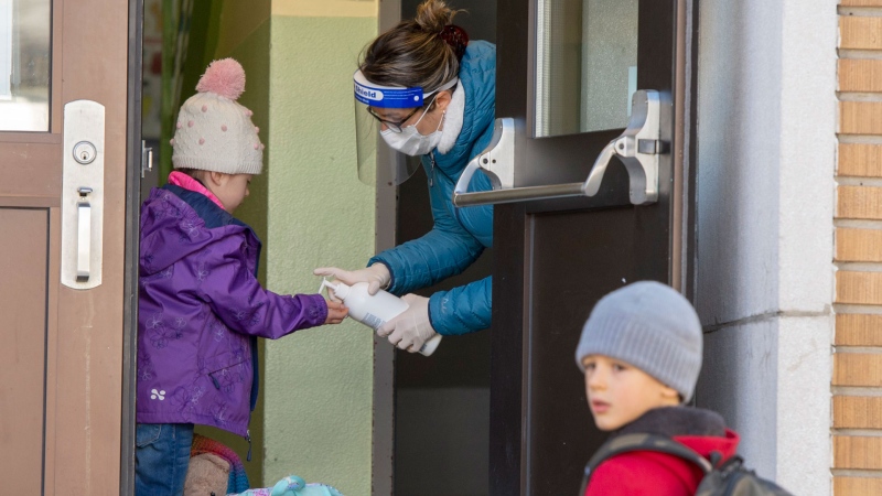 Students get their hands sanitized as they enter Ecole Marie Rose as elementary schools outside the greater Montreal area reopen Monday May 11, 2020 in Saint Sauveur, Que. THE CANADIAN PRESS/Ryan Remiorz