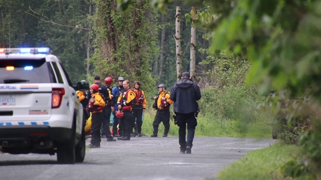 Police and search crews gather on May 12, 2020 near the Vedder River, where a 22-year-old man from India disappeared while swimming with friends on Monday. 