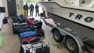 U.S. Customs and Border Protection agents pose for a photograph with a boat and duffel bags allegedly containing marijuana. (U.S. Customs and Border Protection)