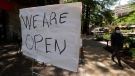 A man wearing a face mask for protection against COVID-19 passes a business that has reopened on the River Walk in San Antonio, Thursday, May 14, 2020. Texas attorney general Ken Paxton has warned officials in San Antonio, Austin and Dallas that the cities could face lawsuits if they do not relax coronavirus measures he says go further than state law allows. (AP Photo/Eric Gay)