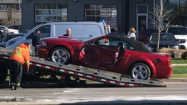 A Ford Mustang T-boned in a crash on Southdale Road, near Wharncilffe Road South, is  loaded onto a flatbed in London, Ont. on Wednesday, May 20, 2020. (Sean Irvine / CTV London)