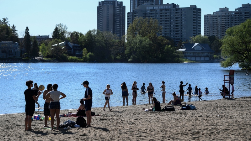 People practice physical distancing as they enjoy the warm weather at Mooney's Bay Beach in Ottawa, on Saturday, May 23, 2020, in the midst of the COVID-19 pandemic. THE CANADIAN PRESS/Justin Tang