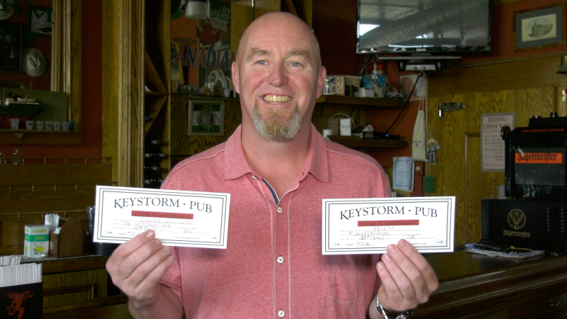 Dan Thompson shows off Keystorm Pub gift cards that are being given to front-line workers in Brockville. (Nathan Vandermeer / CTV News Ottawa)