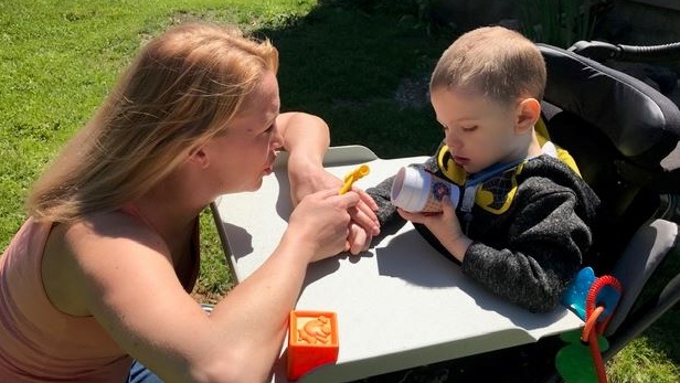 On the front lawn of their home, three-year-old Lincon Bechard falls asleep in specially made wheelchair, just moments after playing excitedly with his mother, Chloe Ribaric. (Sean Irvine/CTV London)