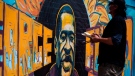 A group of artists paint a mural of George Floyd on the wall outside of Cup Foods, where Floyd was killed in police custody, on May 28, 2020 in Minneapolis, Minnesota. (Stephen Maturen/Getty Images North America/Getty Images)