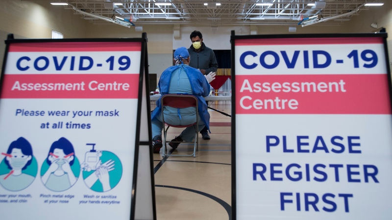 Muhammad Junayed, centre back, gets instructions for being tested for COVID-19 from a health care worker at a pop-up testing centre at the Islamic Institute of Toronto during the COVID-19 pandemic in Scarborough, Ont., on Friday, May 29, 2020. THE CANADIAN PRESS/Nathan Denette