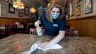 Sara Kennely, cleans one of the dining tables at Max's Allegheny Tavern, Thursday, June 4, 2020. (AP Photo/Keith Srakocic)