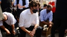 Prime Minister Justin Trudeau takes a knee during an 8 minute and 46 second silence as he takes part in an anti-racism protest on Parliament Hill during the COVID-19 pandemic in Ottawa on Friday, June 5, 2020. He is joined by Minister of Families, Children and Social Development Ahmed Hussen, left and Liberal MP Greg Fergus, right. THE CANADIAN PRESS/Sean Kilpatrick