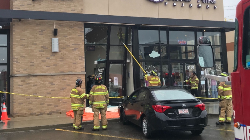 Fire crews helped extricate two people out of a vehicle Saturday after it crashed into a business.(Brandon Lynch/ CTV News Edmonton) 