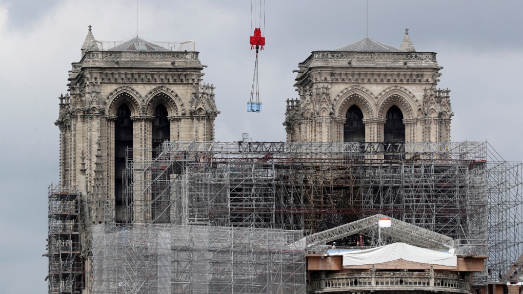 A box hangs from a crane at Notre Dame cathedral