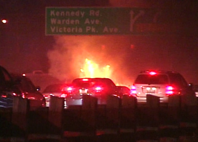 Cars move slowly past the blaze on Hwy. 401 following the accident.
