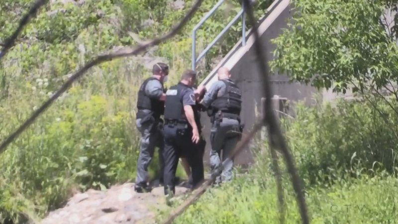 In this still from CTV News video, a man is taken into custody by London, Ont. police officers on the shores of the Thames River opposite Thames Park on Tuesday, June 9, 2020. (Sean Irvine / CTV London)
