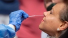Dr. Janice Underwood gets a nasal-swab test by Danielle Edwards, of Chesapeake Regional Healthcare, for COVID-19 at Geneva Square in Chesapeake, Va., on Friday, June 5, 2020. (The' N. Pham/The Virginian-Pilot via AP)
