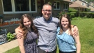 James Smith Poses in his driveway with his daughters Morgan and Anna. They will be assembling a stage in their driveway on June 26 and 27 for special graduation ceremonies. (Rich Garton / CTV Windsor)