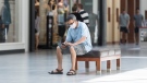 A man sits inside an open shopping mall in Montreal, Saturday, June 20, 2020, as the COVID-19 pandemic continues in Canada and around the world. THE CANADIAN PRESS/Graham Hughes