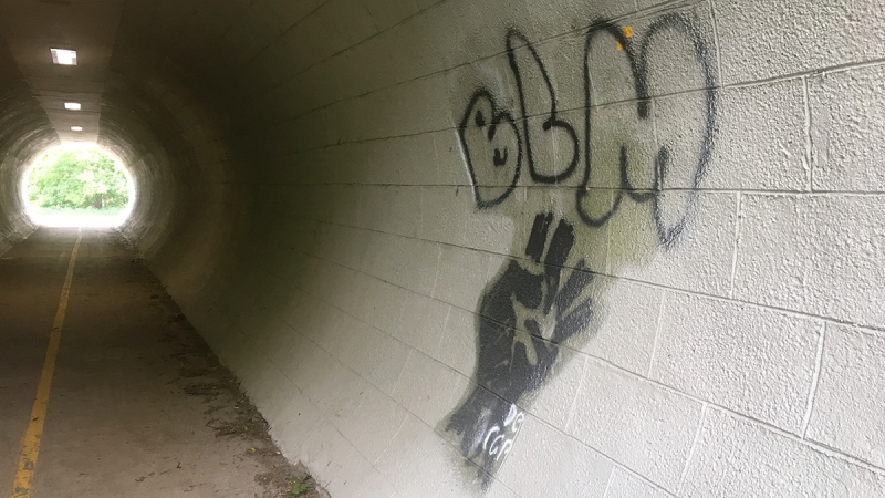 Black Lives Matter graffiti is seen along the Thames Valley Parkway in London, Ont. on Wednesday, June 24, 2020. (Brent Lale / CTV News)