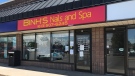 A sign on the door of Binh's Nails and Spa in Kingston says a customer tested positive for COVID-19. (Kimberley Johnson/CTV News Ottawa)