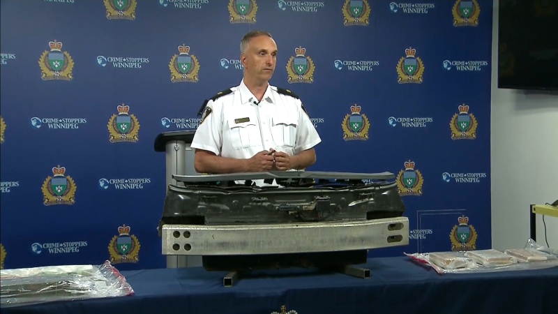 Inspector Max Waddell with the Winnipeg Police Service discusses arrests into an interprovincial drug trafficking network Friday morning. In front of Waddell is a "concealment trap" from a car, which police allege was used to hide drugs. 