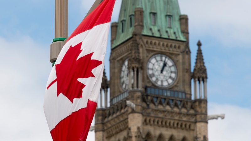 A Canadian flag hangs from a lamp post along the road in front of the Parliament buildings ahead of Canada Day in Ottawa, Tuesday, June 30, 2020. Celebrations on Parliament Hill were cancelled this year due to the COVID-19 pandemic. (Adrian Wyld/THE CANADIAN PRESS)
