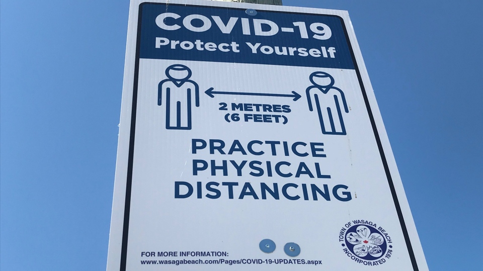 COVID physical distancing sign at beach 
