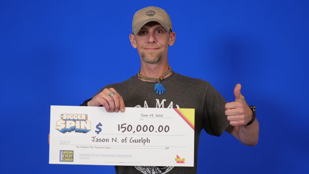 A man gives a thumbs-up with a cheque for $150,000