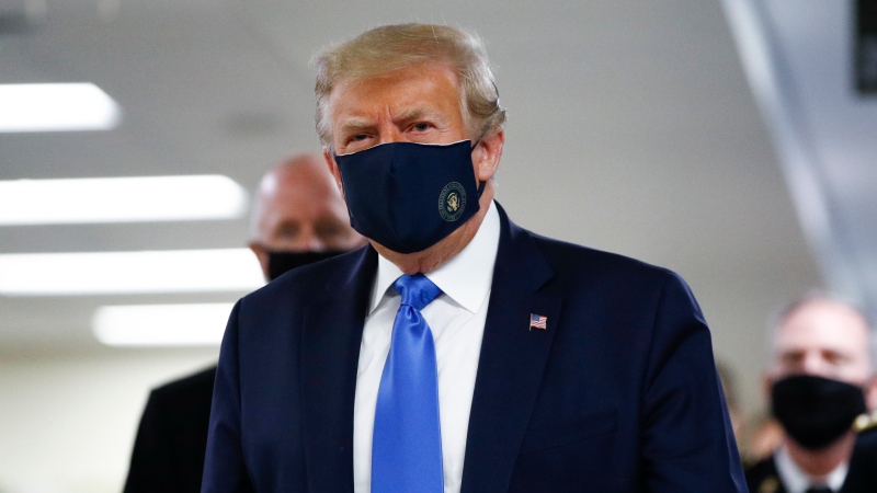 U.S. President Donald Trump wears a mask as he walks down the hallway during his visit to Walter Reed National Military Medical Center in Bethesda, Md., Saturday, July 11, 2020. (AP Photo/Patrick Semansky)