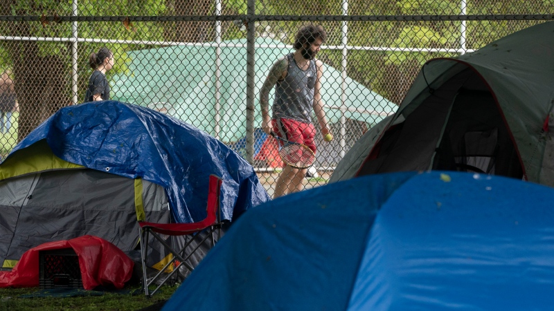 Tennis players play on courts next to the tent encampment at Moss Park in Toronto on Friday, May 29, 2020. THE CANADIAN PRESS/Frank Gunn
