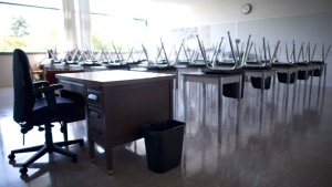 An empty teacher's desk is seen at the front of a empty classroom at in 2014. THE CANADIAN PRESS/Jonathan Hayward