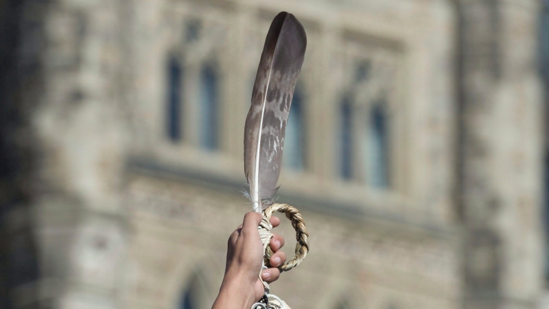 An eagle feather is held up during a rally for Missing and Murdered Indigenous Women and Girls on Parliament Hill in Ottawa on October 4, 2016.THE CANADIAN PRESS/Adrian Wyld