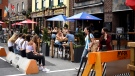 People sit at an outdoor patio at a bar in the ByWard Market in Ottawa, as others wait for a table, on Sunday, July 12, 2020, in the midst of the COVID-19 pandemic. (Justin Tang/THE CANADIAN PRESS)