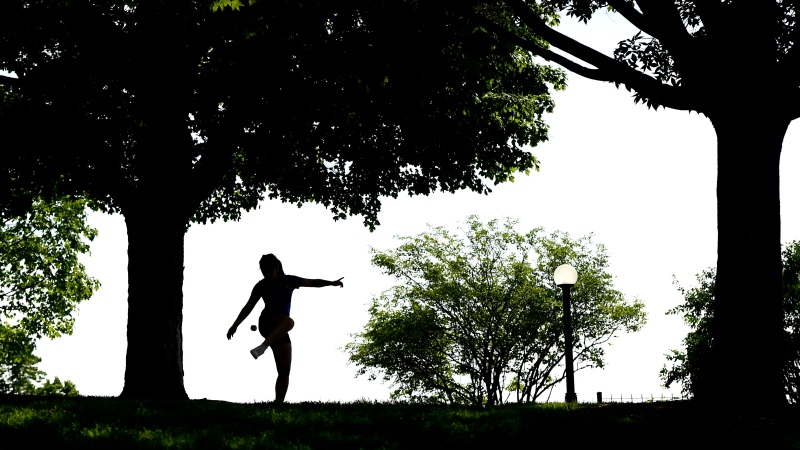 A woman plays hacky sack in Major's Hill Park in Ottawa, on Sunday, July 12, 2020, in the midst of the COVID-19 pandemic. (Justin Tang/THE CANADIAN PRESS)