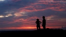 A couple watch the sunset from a park, Friday, July 3, 2020, in Kansas City, Mo. THE CANADIAN PRESS/AP-Charlie Riedel