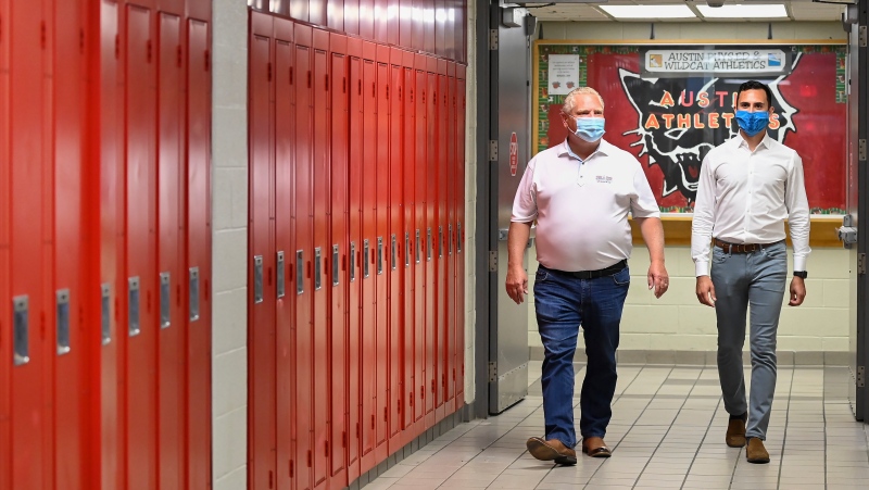 Ontario Premier Doug Ford, left, and Education Minister Stephen Lecce walk the hallway before making an announcement regarding the governments plan for a safe reopening of schools in the fall due to the COVID-19 pandemic at Father Leo J Austin Catholic Secondary School in Whitby, Ont., on Thursday, July 30, 2020. THE CANADIAN PRESS/Nathan Denette