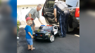Young Chase, reacting to a gift of a battery-powered police cruiser from Const. Craig Kelso. (Photo courtesy of Patty Baird)