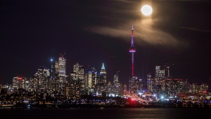 The moon rises behind the skyline in Toronto, Friday January 13, 2017. THE CANADIAN PRESS/Mark Blinch
