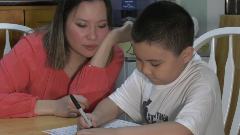 Kaye Banez helps her eight-year-old son, Lazarus, study in their family kitchen on Aug. 20, 2020. 