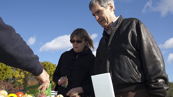 Liberal Party Leader Michael Ignatieff, right, and his wife Zsuzsanna Zsohar buy potatoes at the local Farmers Market at Landsdown Park in Ottawa on Sunday, Oct. 11, 2009. (Powel Dwulit / THE CANADIAN PRESS)