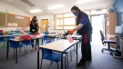 Joshua Lee, right, disinfects tables at Queen's Hill Primary School in Costessey near Norwich, England, Monday, Aug. 24, 2020.(Joe Giddens/PA via AP)