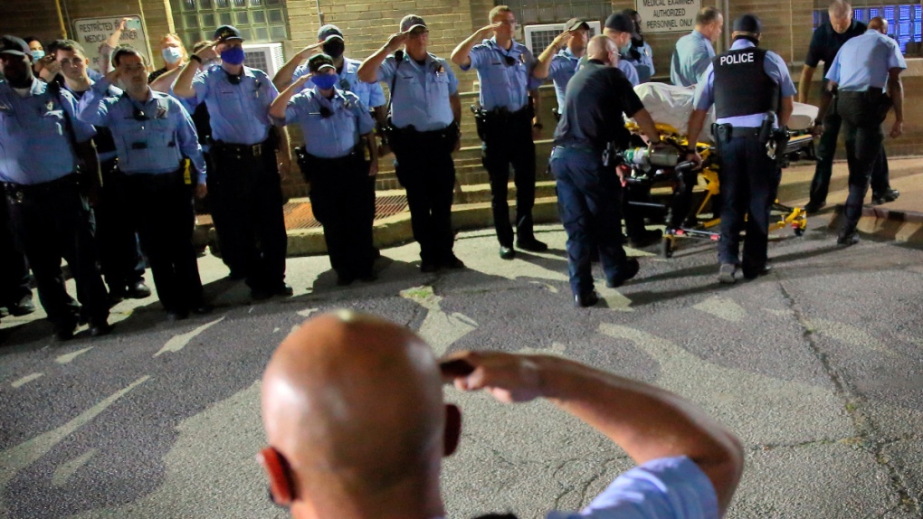 St. Louis police officers line up and salute