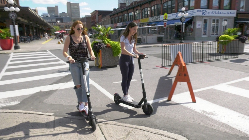 Two women ride e-scooters in Ottawa's ByWard Market, Aug. 31, 2020. (Dave Charbonneau / CTV News Ottawa)