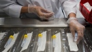 Employees work at the Canadian Hospital Specialities (CHS) helping take dual COVID-19 testing swab kits and separating them into two units to help with swab capacity during the COVID-19 pandemic in Oakville, Ont., on Monday, June 8, 2020. THE CANADIAN PRESS/Nathan Denette