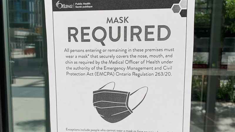 A sign requiring mask be worn in common areas of condo and apartment buildings is posted on a door in Ottawa. (Leah Larocque/CTV News Ottawa)